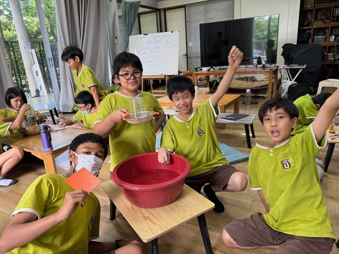 เด็กๆ ตื่นเต้นกับการคว่ำแก้วน้ำบนกระชอนแล้วน้ำไม่หก
